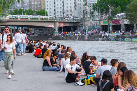 VIENNA, AUSTRIA - MAY 25: Many people are relaxing with alcohol drinks on a day off in a beautiful summer weather on the banks of the Danube Canal(Donaukanal) in Vienna, Austria, on May 25, 2019.のeditorial素材