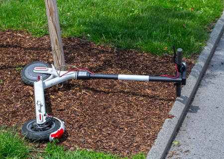 Modern city transport - electric scooters is lying on the lawn.