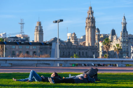 Spain, Barcelona - Jan 01, 2012: People Local and tourists have are rest and relaxing and walk in a leisurely way in a beautiful sunshine warm weather on a seafront Rambla De Mar near Maremagnum mall.のeditorial素材