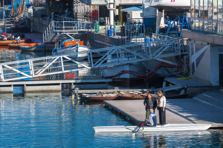 Spain, Barcelona - Jan 01, 2012: People Local and tourists have are rest and relaxing and walk in a leisurely way in a beautiful sunshine warm weather on a seafront Rambla De Mar near Maremagnum mall.のeditorial素材