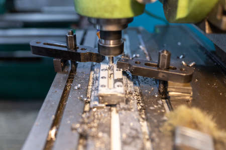 Execution of the work process on an industrial milling machine. The metal part is clamped in the...