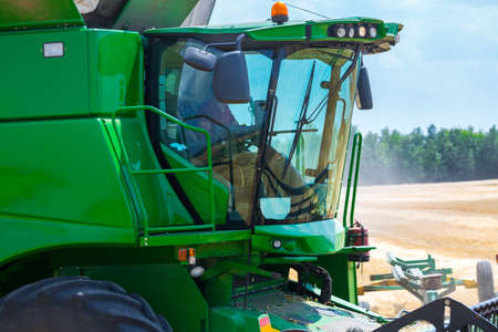 The machine for harvesting grain crops - combine harvester in action on rye field at sunny summer...