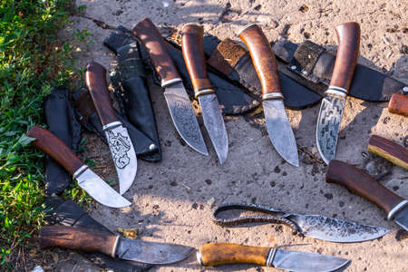 Ð¡raft handmade hunting knives styled on damascus steel, are lying on the concrete floor.の写真素材