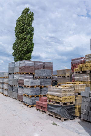 Industrial production of building cement pressed materials. High quality hollow concrete block or cement brick and paving stones. Finished products on pallets packed in film are waiting to be shipped.の写真素材