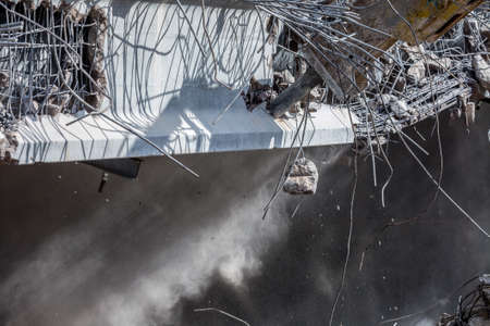 Professional demolition of reinforced concrete structures using industrial hydraulic hammer. Rods of...