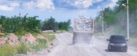 A dump truck loaded mined granite in a quarry open pit mining of granite stone. Process production stone and gravel. Quarry mining equipment.の写真素材