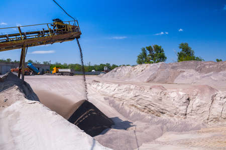 Crushing machinery, cone type rock crusher, conveying crushed granite gravel stone in a quarry open pit mining. Processing plant for crushed stone and gravel. Mining and Quarry mining equipment.の写真素材