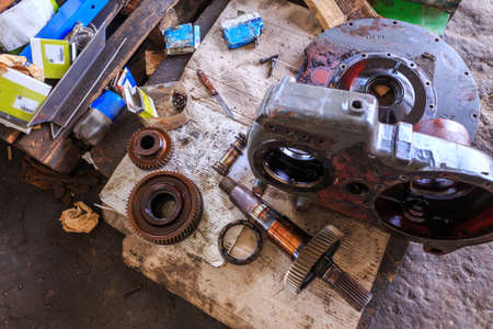 Metal spare parts: bearings, gears, shaft, gear shaft. Spare parts of disassembled engines of large agricultural machinery. Floor repair garage. Concept theme: repair, mechanics, production, industryの写真素材