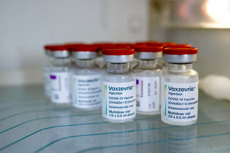 Khotyn, Ukraine - OCT 18 2021: A vaccin doses of Vaxzevria/COVID-19 AstraZeneca in a vials into a...