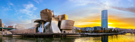 Bilbao, Spain - NOV 20, 2021: awesome evening panoramic view of The Guggenheim Museum designed by Frank Gehry and embankment Estuary of Bilbao and skyscraper of energy company IBERDROLAのeditorial素材