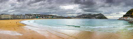 dramatic autumn panoramic view of La Concha sand beach and Island de Santa Clara in the bay at old town center of San Sebastian, Donostia, Gipuzkoa, Basque Country - warm winter in Spainの写真素材