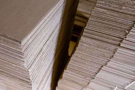 Folding cardboard boxes. Perforated sheets of corrugated cardboard are stacked on pallets. Packaging of finished products in industrial production.の写真素材