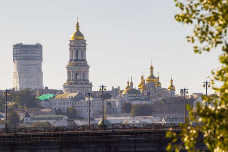 Bright evening cityscape of the big city on the hill over wide river Dnipro in awesome bright sunset in Kyiv, Ukraine. View at Kyiv-Pechersk Lavra National Reserve.の写真素材