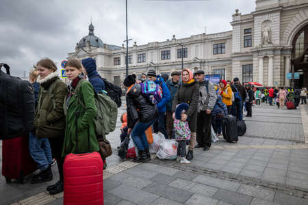 LVIV, UKRAINE - APR 02, 2022: Volunteer and refugees who have just arrived by evacuation train from...