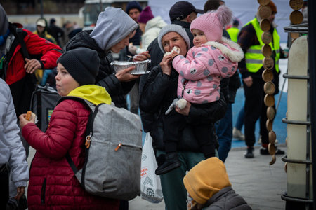 LVIV, UKRAINE - APR 02, 2022: Volunteers in tent camp of World Central Kitchen and Red Cross helping to feed and aid thousands of refugees flee war-torn territories to Europe at Lviv Railway Station.のeditorial素材