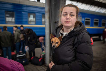 LVIV, UKRAINE - APR 02, 2022: Humanitarian catastrophe during at war in Ukraine. Refugees with a pet small chihuahua dog from Mariupol are flees to Europe at the Lviv Railway Station.のeditorial素材