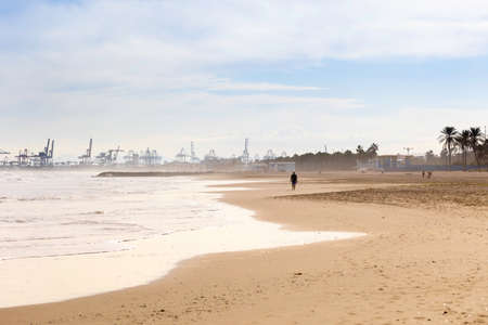 Summer vibes on the sunny autumn beach of Malvarrosa in Valencia, Spain. Vast expanses of smooth...