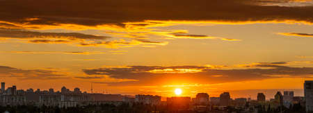 Amazing panoramic view of the big city evening silhouette against the backdrop of incredibly, awesome bright, multi colored clouds at sunset. Kyiv in last days in july 2022. Ukraine.の写真素材