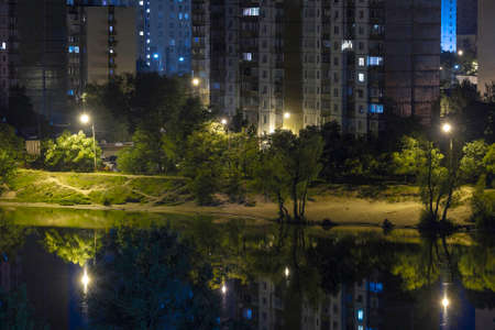 Night cityscape of the big city. Awesome bright, multi colored light at curfew on empty streets. Apartment buildings in bedroom community, commuter town area. Kyiv in last days in july 2022. Ukraine.の写真素材
