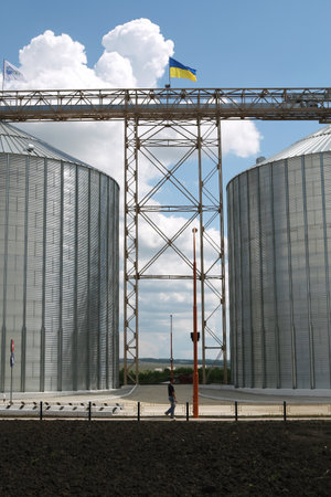 Kamyanets-Podilsky, Ukraine - JULY 29 2008: Galvanized steel grain silos of Nibulon - one of the largest agricultural company specializing in production and export of grains wheat, barley, corn.のeditorial素材