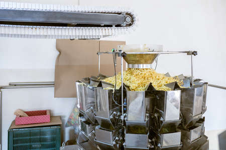 sorting and packing line of snack onion ring at factory conveyor for cereal snack production of flour products, technology production in food Industryの写真素材