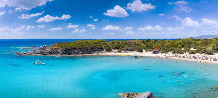 Crystal clear turquoise water in a Glystra beach. Cane umbrellas and sunbeds on an beach resort -...