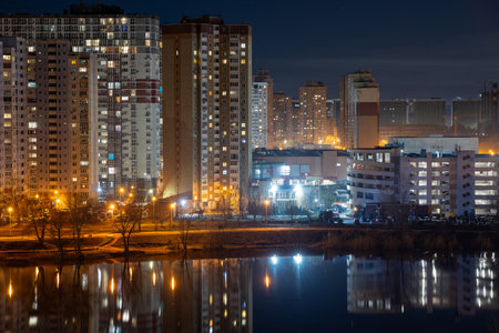 Night cityscape of the big city. Bright, multi colored light on empty streets. Apartment buildings in bedroom town area. Kyiv in end of march 2024. Ukraine.の写真素材
