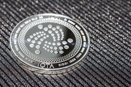 Silver coin cryptocurrency IOTA. MIOTA on grey background.の写真素材