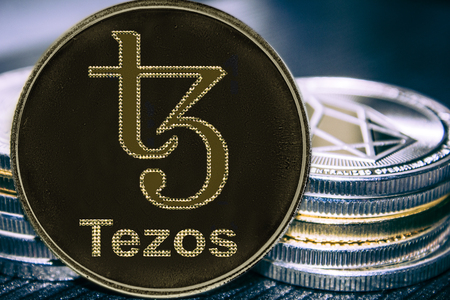Coin cryptocurrency Tezos on the background of a stack of coins. XTZ coin.の写真素材