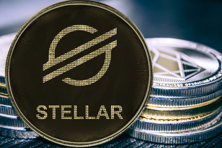 New token cryptocurrency Stellar on the background of a stack of coins. XLM coin.の写真素材