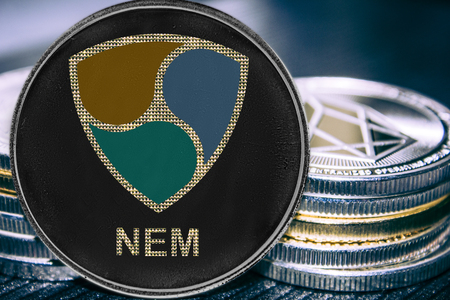 Coin cryptocurrency NEM on the background of a stack of coins. Crypto token XEM.の写真素材