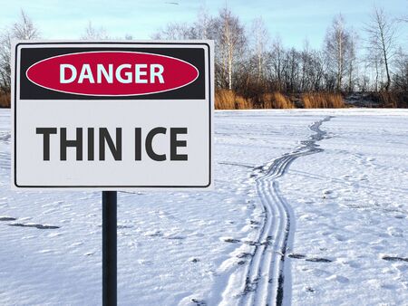 sign thin ice and footprints and road on snow and iceの写真素材