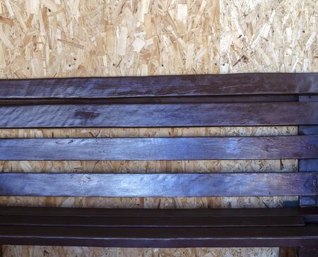 wooden brown painted bench against the background of a large shavings senkaの写真素材