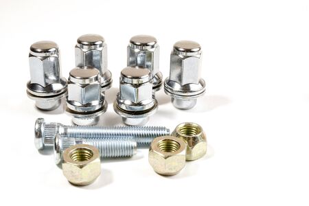 close-up on a white background a lot of different new nuts and bolts for car wheels