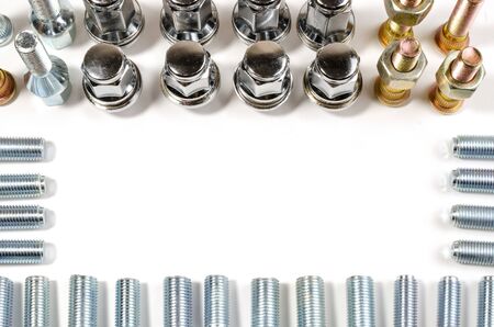 close-up on a white background a lot of different new nuts and bolts for car wheels with a place for...