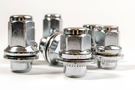 close-up on a white background a lot of different new nuts and bolts for car wheelsの写真素材