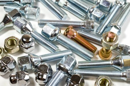 close-up on a white background a lot of different new nuts and bolts for car wheelsの写真素材