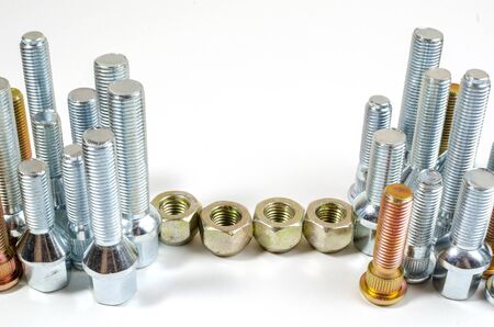 nuts and upright studs and bolts for a car on a table with a place for inscriptionの写真素材