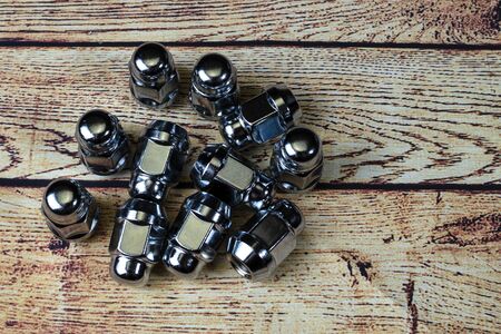 Car service, car wheel fastener nut on a wooden table