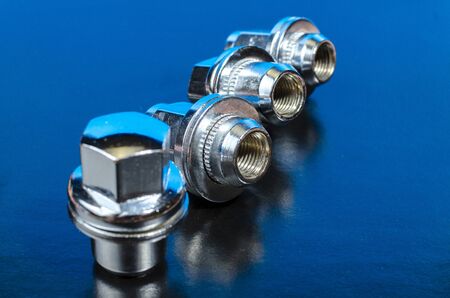 New union nuts for car wheels on a blue background - auto parts