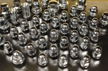 many new car wheel nuts, closeup abstract background
