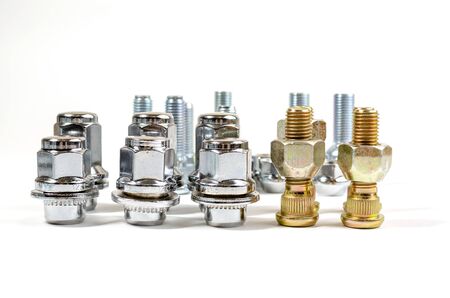 close-up on a white background a lot of different new nuts and bolts for car wheels