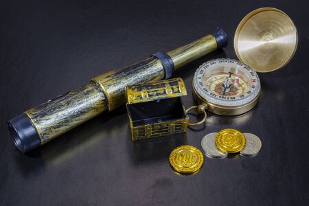 pirate treasure chest, old mars compass and spyglass on a black backgroundの写真素材