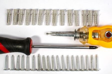 chromed screws and dowels for mounting on a white background with a tool