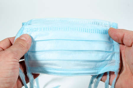 man holds a protective mask in his hand, worries about coronovirus