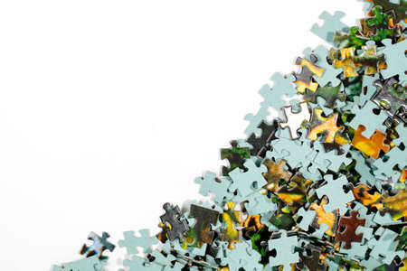 Pieces of a multicolored puzzle lie chaotically in a large pileの写真素材