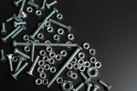 many metal bolts and nuts against black backgroundの写真素材