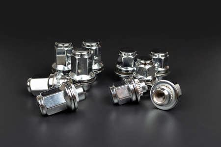 shiny metal nuts on black background with copy space
