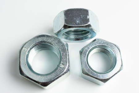 several large metal nuts on a white background