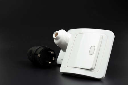close-up of electrical outlet, plugs and light switch on black backgroundの写真素材